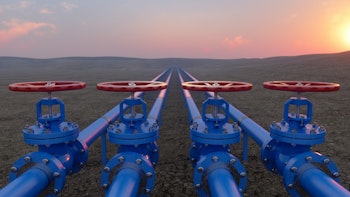 Oil or gas transportation with blue gas or pipeline valves on soil, sunrise background