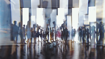 Abstract silhouettes of people reflected in mirror-like glass panelling