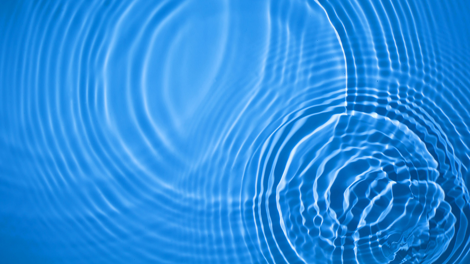 Circular ripples on clear blue water