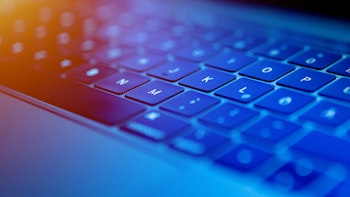 Keyboard with blue lighting, photographed from the side on a diagonal