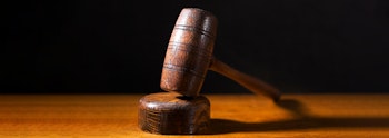 Wooden gavel on a wooden table with a black background