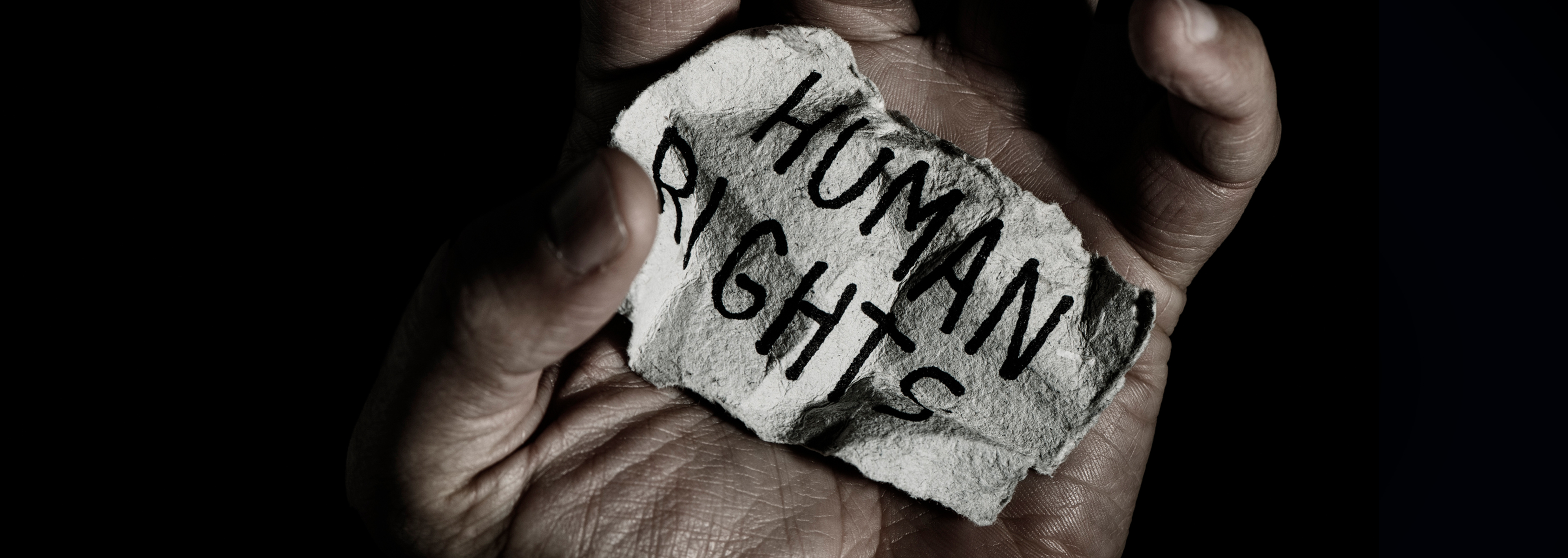 Hand holding paper with Human Rights on it